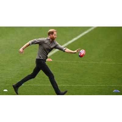 El príncipe Enrique practica fútbol australiano en su visita al país junto a Meghan Markle